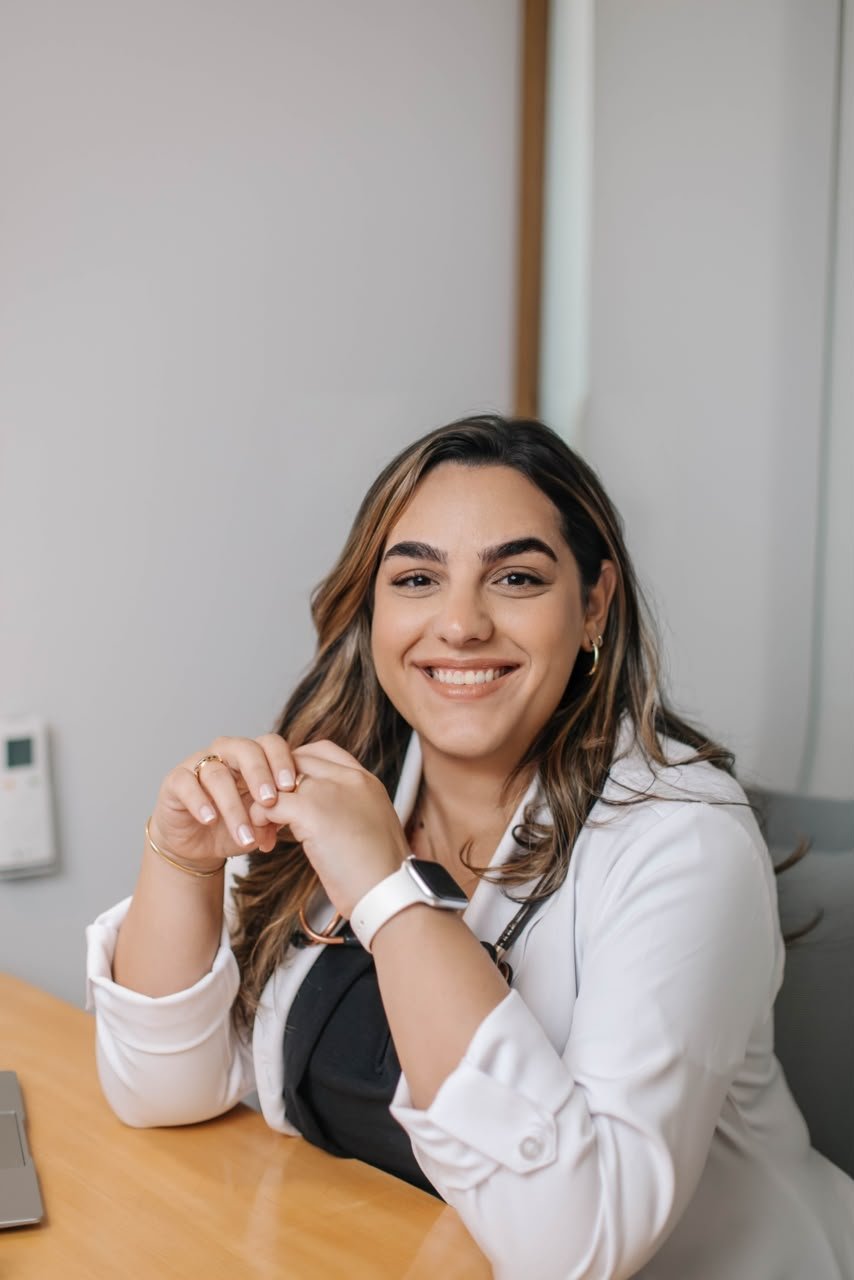 Dra. Julia Miranda sorrindo em seu consultório